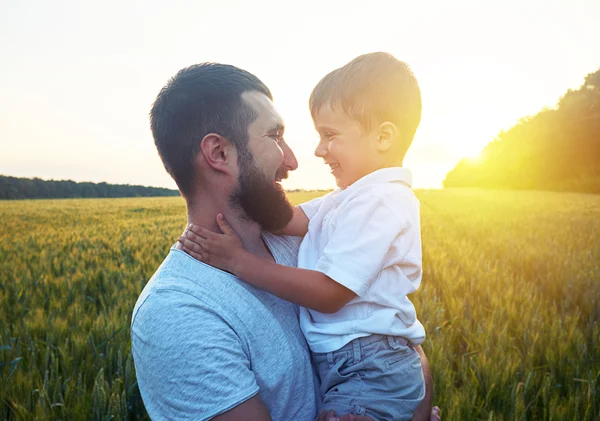 Vater und kleiner Sohn schauen sich bei Sonnenuntergang an — Stockfoto