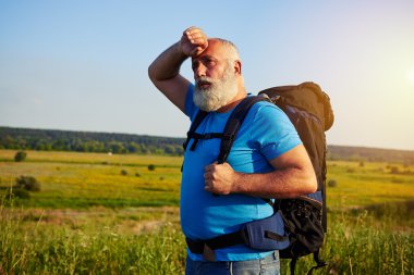 Yaşlı adam alanında ayakta ve onun silerek sırt çantası ile uygun 