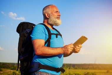 Yaşlı adamla yakışıklı adam sırt çantası ve veri tablete