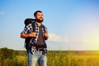 Adam alanında ayakta ve zevk sırt çantası ile gülümseyen