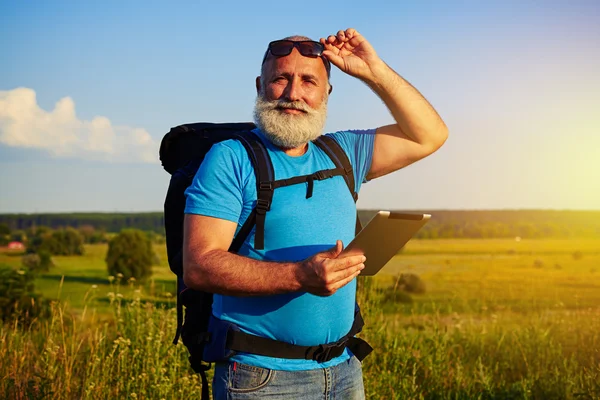 Portrait of man with white beard carrying a rucksack and data ta — Stock Photo, Image
