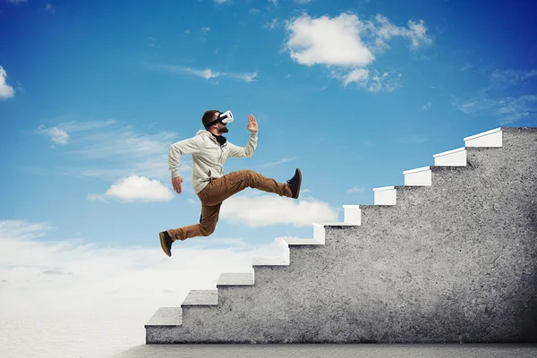 Человек в очках виртуальной реальности бежит вверх по лестнице по небу ба — стоковое фото