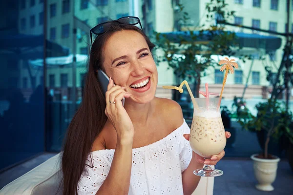 Young beautiful woman with cocktail in cafe in downtown — Stock Photo, Image