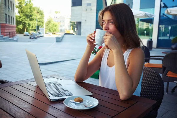 Jonge vrouw buitenshuis in straat café drinken koffie terwijl STREVE — Stockfoto