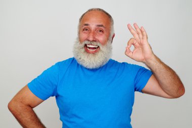 Beyaz sakallı yaşlı adam ve geniş bir gülümseme Ok jest gösteren
