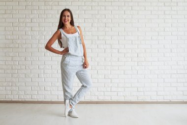 Gülümseyen güzel esmer parmak parmak üzerinde bir ayak ile ayakta ve 