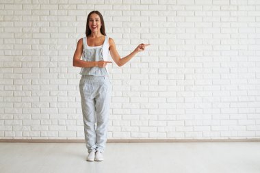 Gülümseyen güzel esmer ayakta ve her iki eliyle puan t