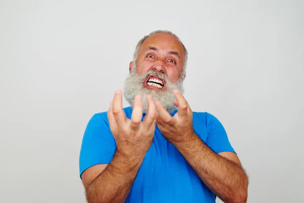 Homem barbudo envelhecido sorrindo para a câmera expressando nerv extremo — Fotografia de Stock