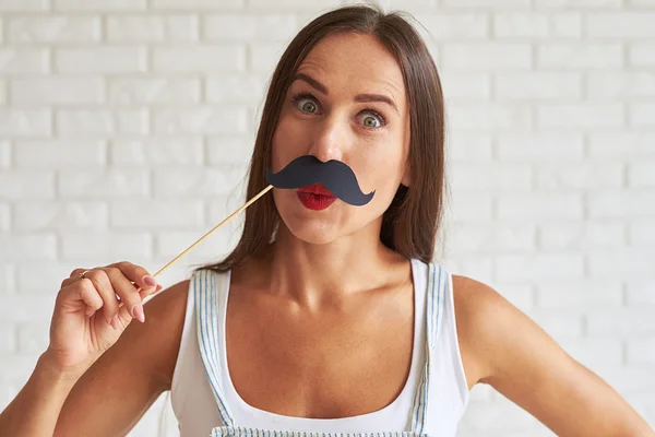 Incroyable jolie brune tenant un masque de moustache — Photo