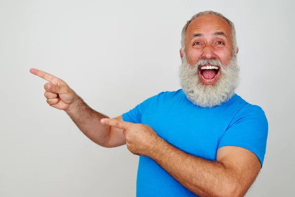 Varón barbudo haciendo gestos de felicidad y señalando con los dedos a hi — Foto de Stock