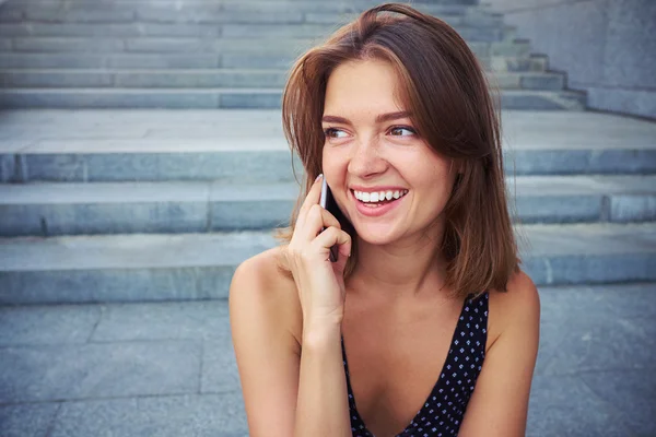 Una chica atractiva tiene una conversación bastante animada en su p inteligente —  Fotos de Stock