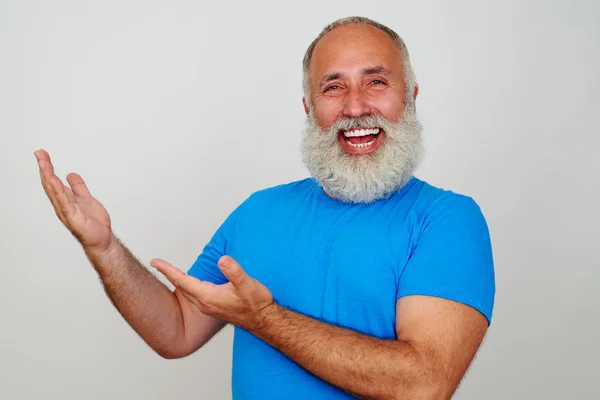 Fröhlicher bärtiger alter Mann, der mit den Händen zur Seite zeigt — Stockfoto