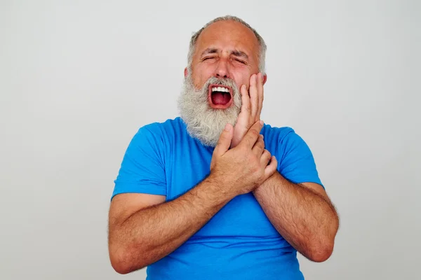 Skäggiga mannen vidrör hans kind som om att ha svår tandvärk — Stockfoto