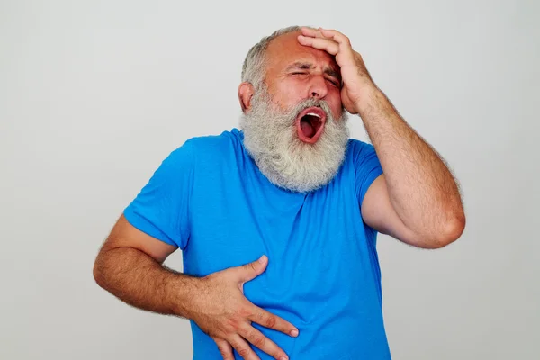 Homem barbudo expressivo gesticulando cabeça e dor de estômago — Fotografia de Stock