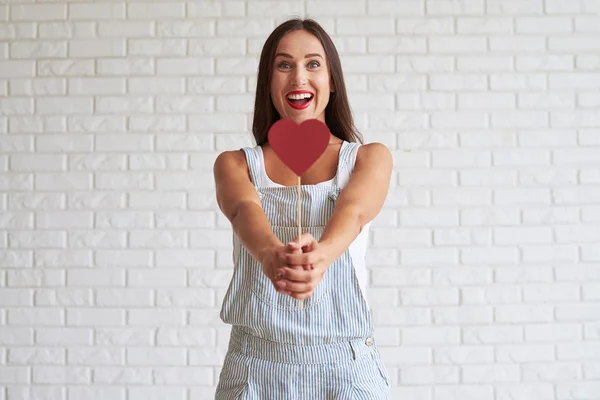 Gelukkig mooie brunette houden rood papier hart voor haar — Stockfoto