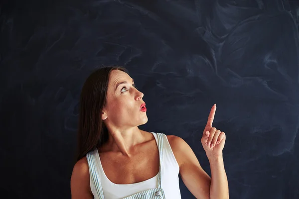 Bella giovane donna sta guardando e puntando il dito verso l'alto — Foto Stock