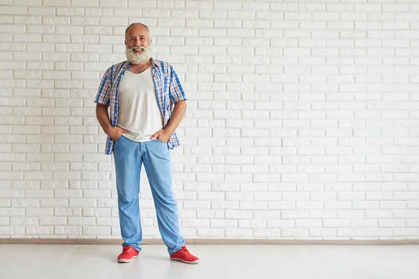 Sorrindo de pé sênior e de mãos dadas em seus bolsos — Fotografia de Stock