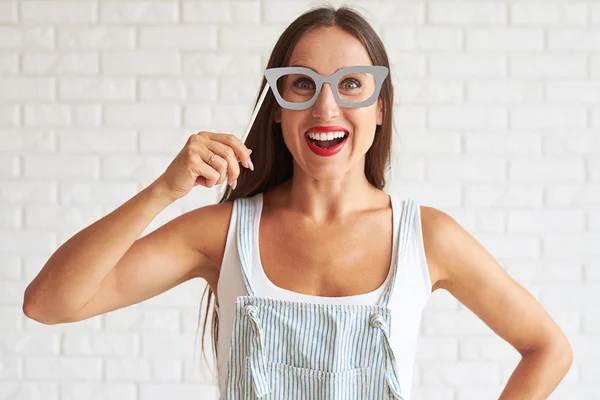 Smiling woman holding big glasses-mask and smiling — Stock Photo, Image