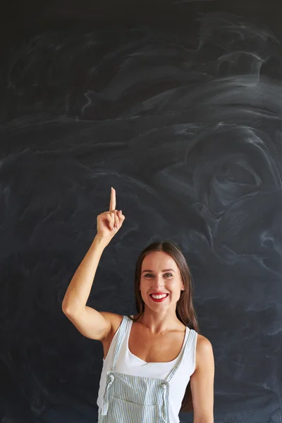 Mujer feliz joven señala con el dedo hacia arriba — Foto de Stock