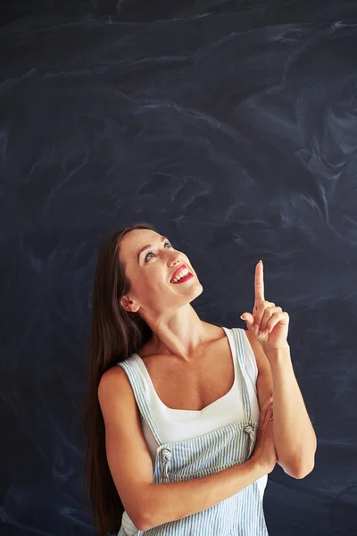 Junge Frau zeigt mit dem Finger nach oben — Stockfoto