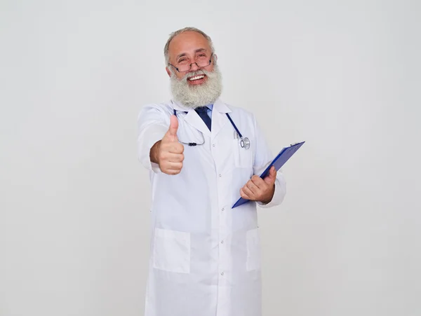 En glad mogen läkare håller tummen upp — Stockfoto
