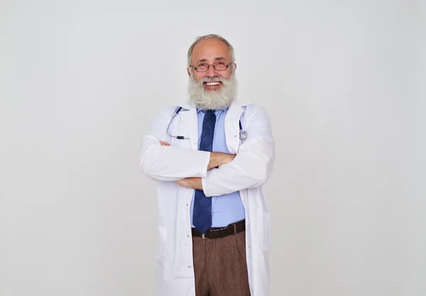 Um retrato de médico barbudo sênior encantado com as mãos cruzadas — Fotografia de Stock
