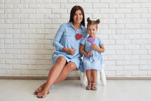 Nahaufnahme der eleganten stilvollen Mutter und ihrer Tochter beim Sitzen — Stockfoto