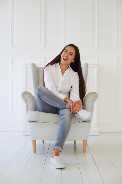 Retrato de primer plano de mujer alegre y riéndose suavemente mientras se sienta — Foto de Stock