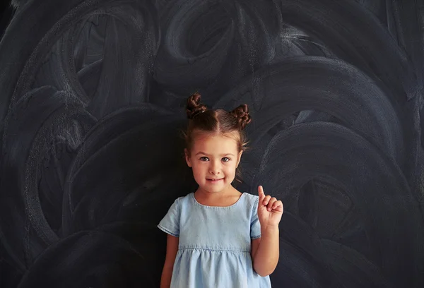 Little cute girl holding finger up — Stock Photo, Image