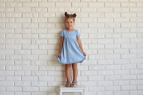 Retrato de pequeña chica linda moda sobre fondo de ladrillo blanco — Foto de Stock