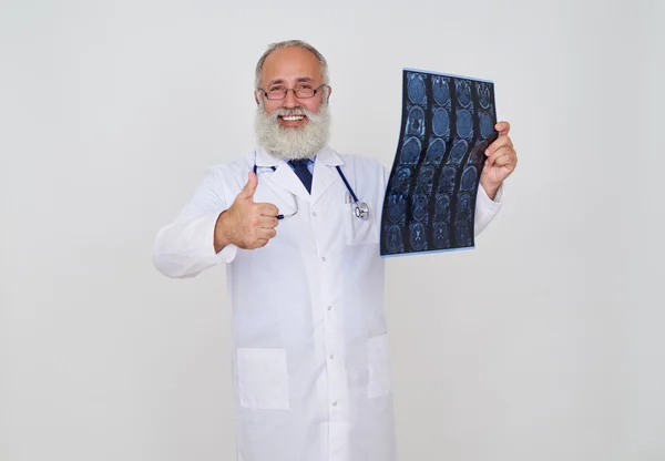 Усміхнений лікар робить, добре жест, під час вивчення томографії — стокове фото