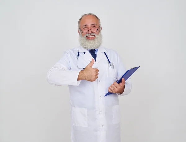 Médico sorrindo fazendo ok, gesto com uma pasta e estetoscópio — Fotografia de Stock