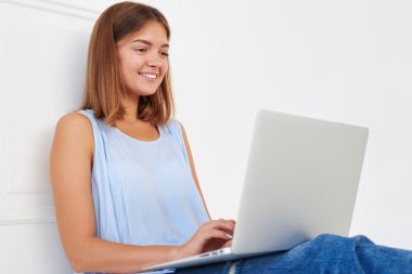 Young modern girl smiling softly in reply on a message 