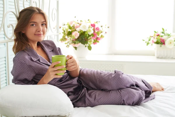 Yatak odasında zekâ bir fincan çay ile başucunda Çekici kadın