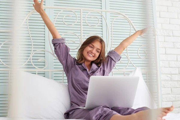 Joyful fêmea de pijama comunicando via chat de vídeo em seu colo — Fotografia de Stock