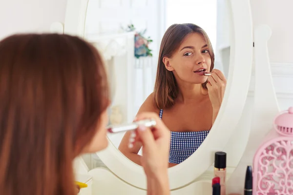 Reflection of young trendy girl putting on lipstick — Stock Photo, Image