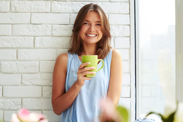 Jovem menina sorriu ensolarado enquanto desfruta de uma xícara de café no — Fotografia de Stock