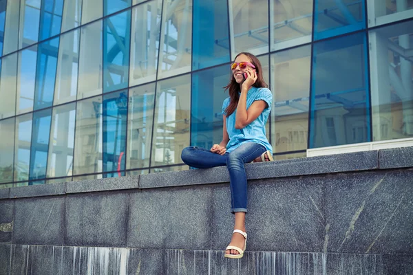 Ragazza caucasica di umore allegro sta parlando su smart phone mentre — Foto Stock