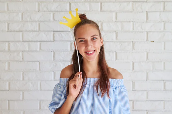 Close-up of cute girl holding paper crown over her head — Stock Photo, Image