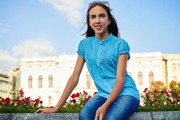 Close-up of teenage girl in bright blue blouse sitting on the fl — Stock Photo, Image
