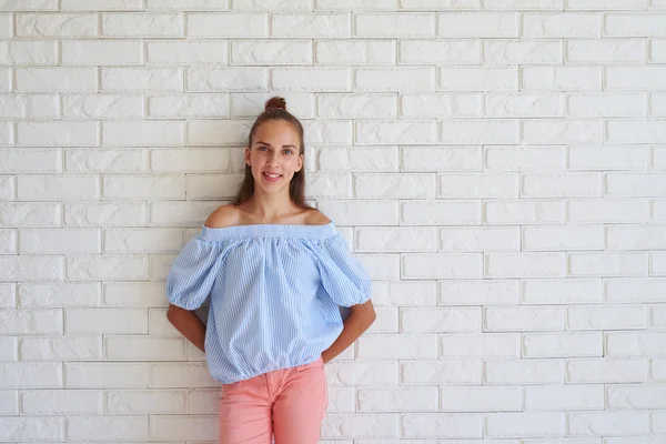 Ragazza felice in piedi con le mani dietro la schiena indossando casua — Foto Stock