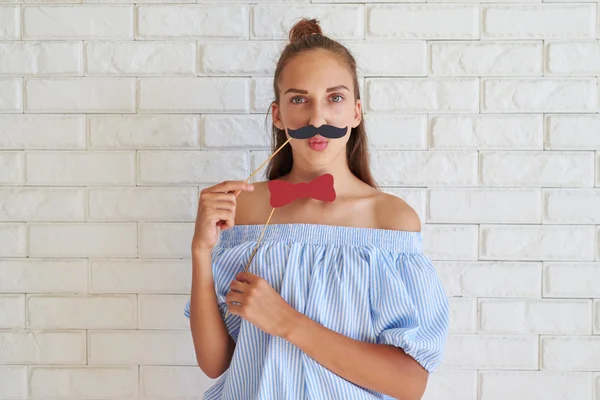 Menina séria em roupas casuais posando com acessórios de papel em — Fotografia de Stock