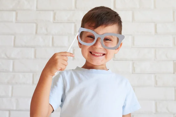 Toothy smile boy holding paper moustache having fun — Stock Photo, Image