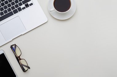Dizüstü bilgisayar, cep telefonu, gözlük ve cu ile Düzenli ofis masası