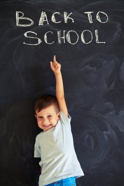 Gülümseyen birinci sınıf öğrencisi bl üzerinde tebeşir yazıt işaret