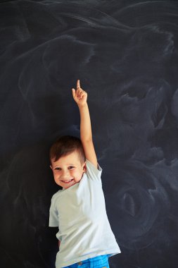 Yukarı doğru uzatılmış kol agai işaret parmağı ile işaret eden küçük bir çocuk