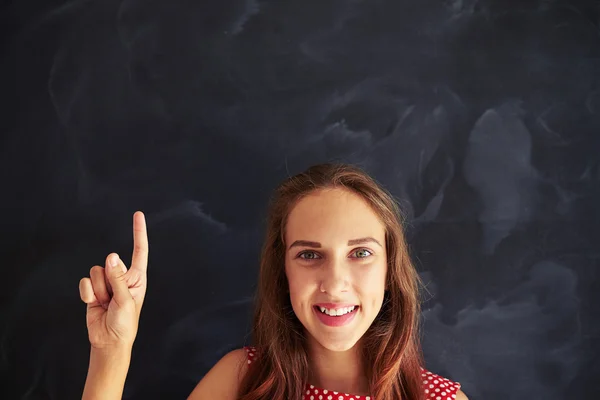 Retrato de cerca de una adolescente sonriente mostrando el dedo índice aga —  Fotos de Stock