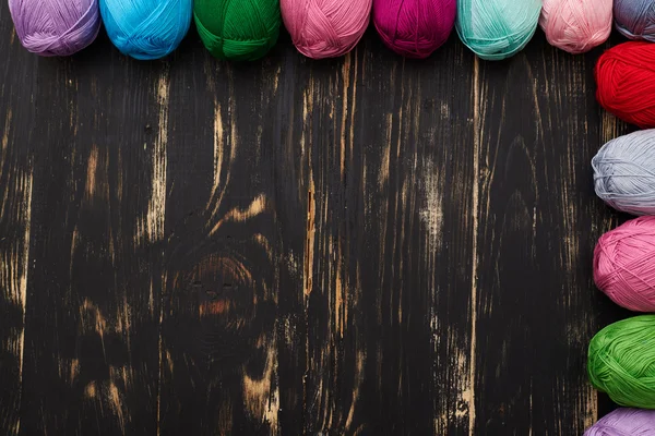 Ansicht von teilweise gesehenen mehrfarbigen Knäueln auf dunklem Holzrücken — Stockfoto