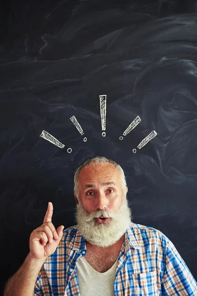 Excited aged bearded man against school blackboard holding a for — Stock Photo, Image