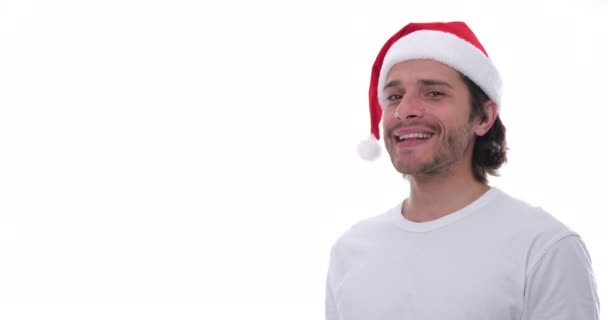 Muž v Santa klobouku ukazuje přes bílé pozadí — Stock video